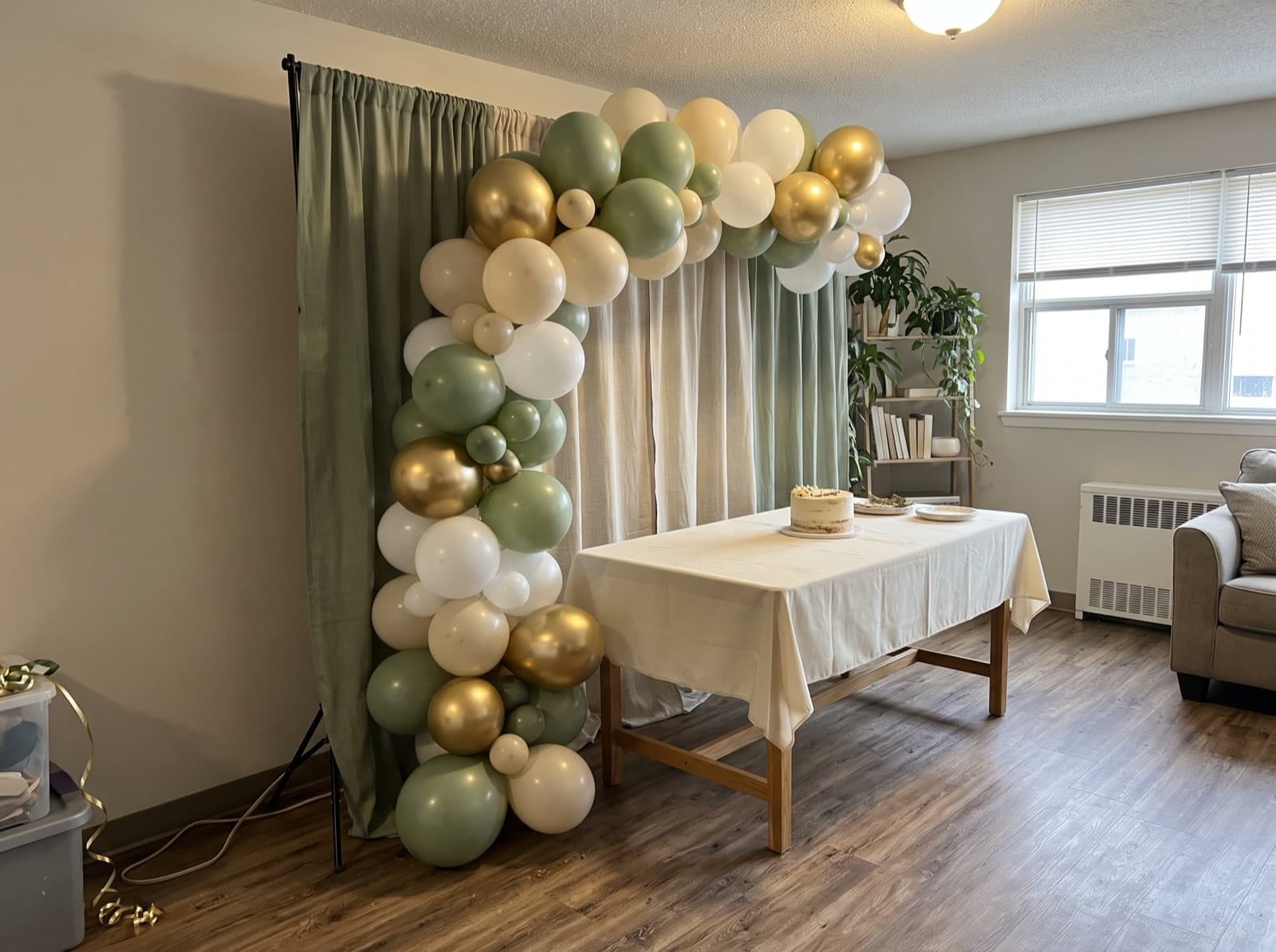 Half balloon arch swooping over a cake table