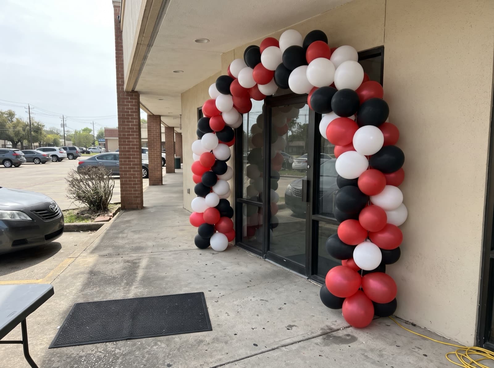 Large balloon arch over a storefront entrance