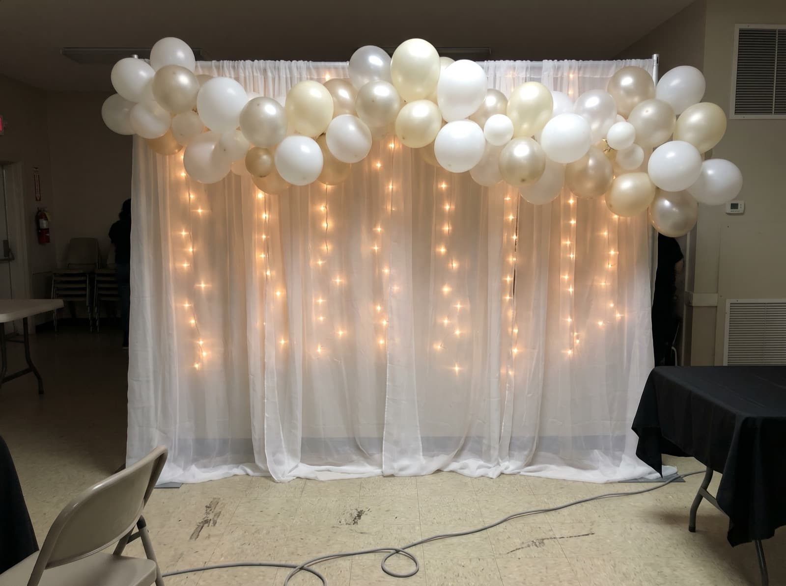 Draped backdrop with balloons and lights