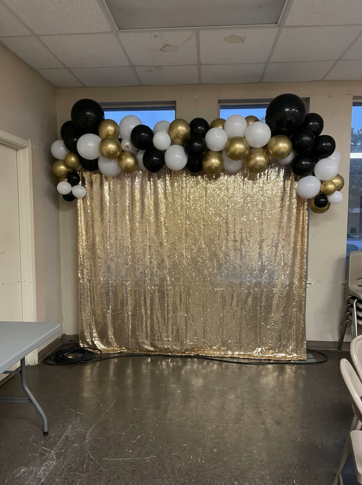 Gold shimmer wall backdrop with a balloon garland