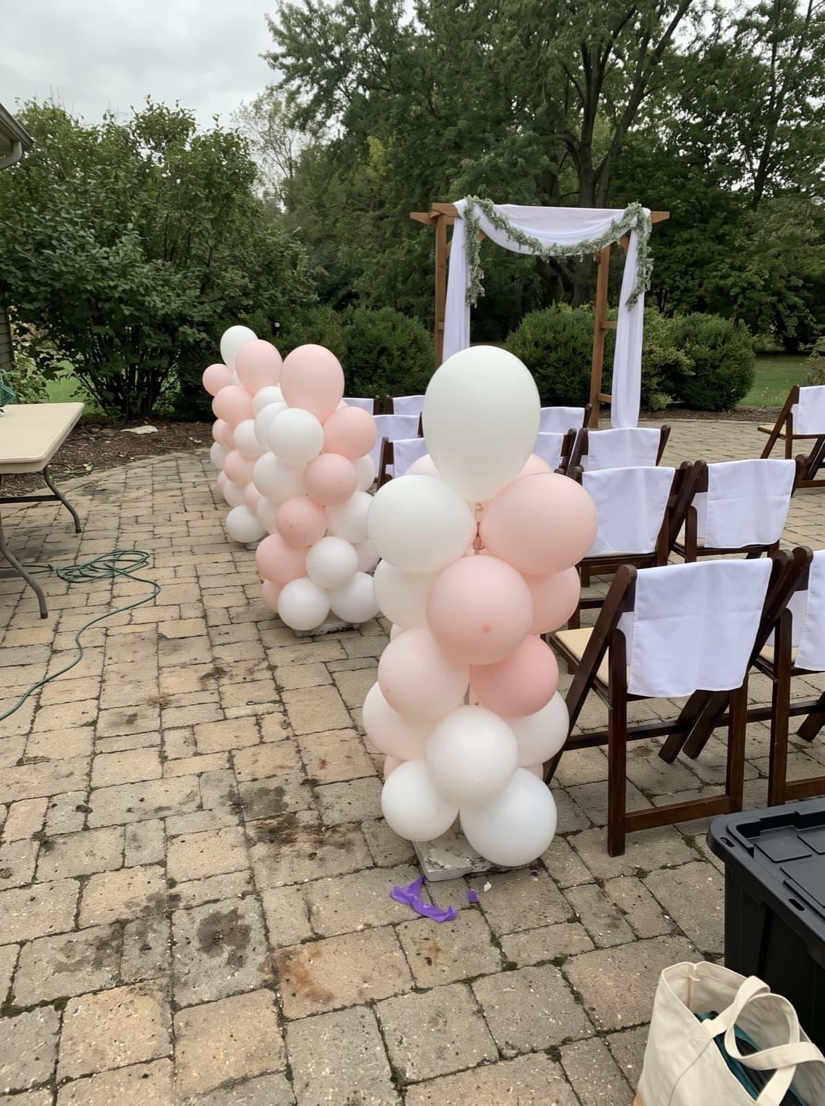 Organic balloon columns lining a wedding aisle