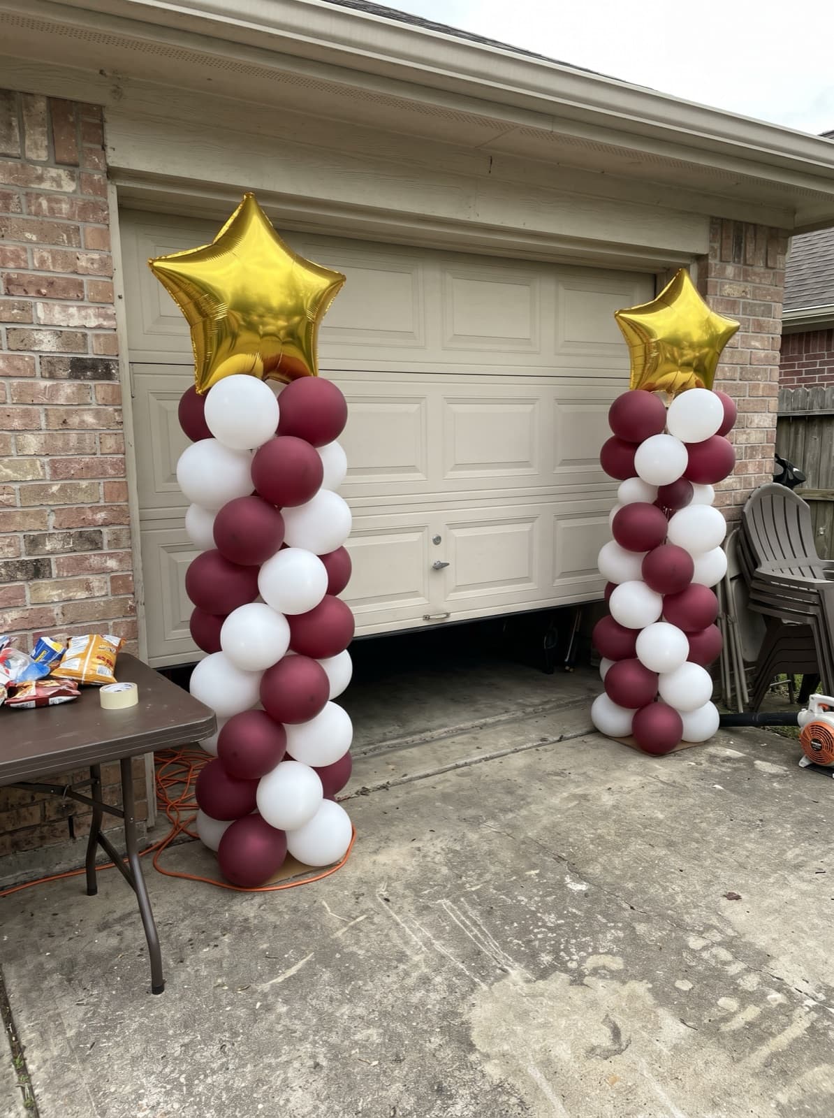 Pair of spiral balloon columns in school colors with star toppers at a graduation party