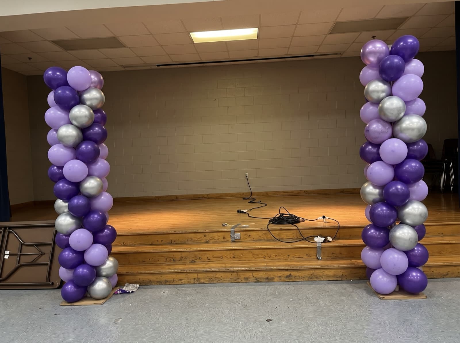 Tall balloon columns on each side of a stage