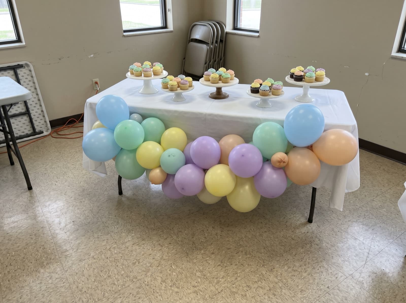 Balloon garland draped across the front of a cake table