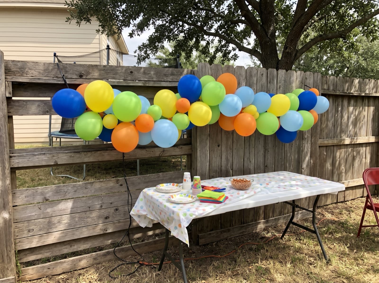 Balloon garland on a backyard fence