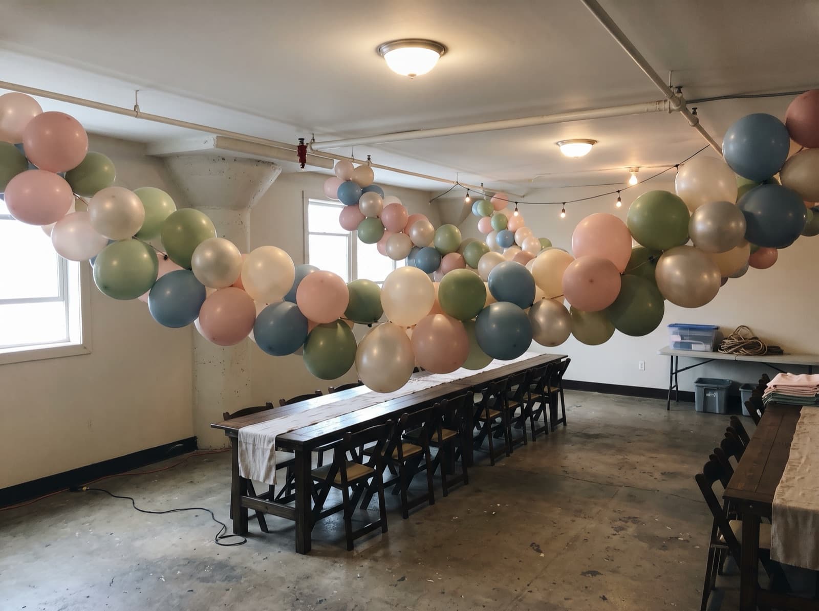 Hanging balloon garland canopy over dining tables